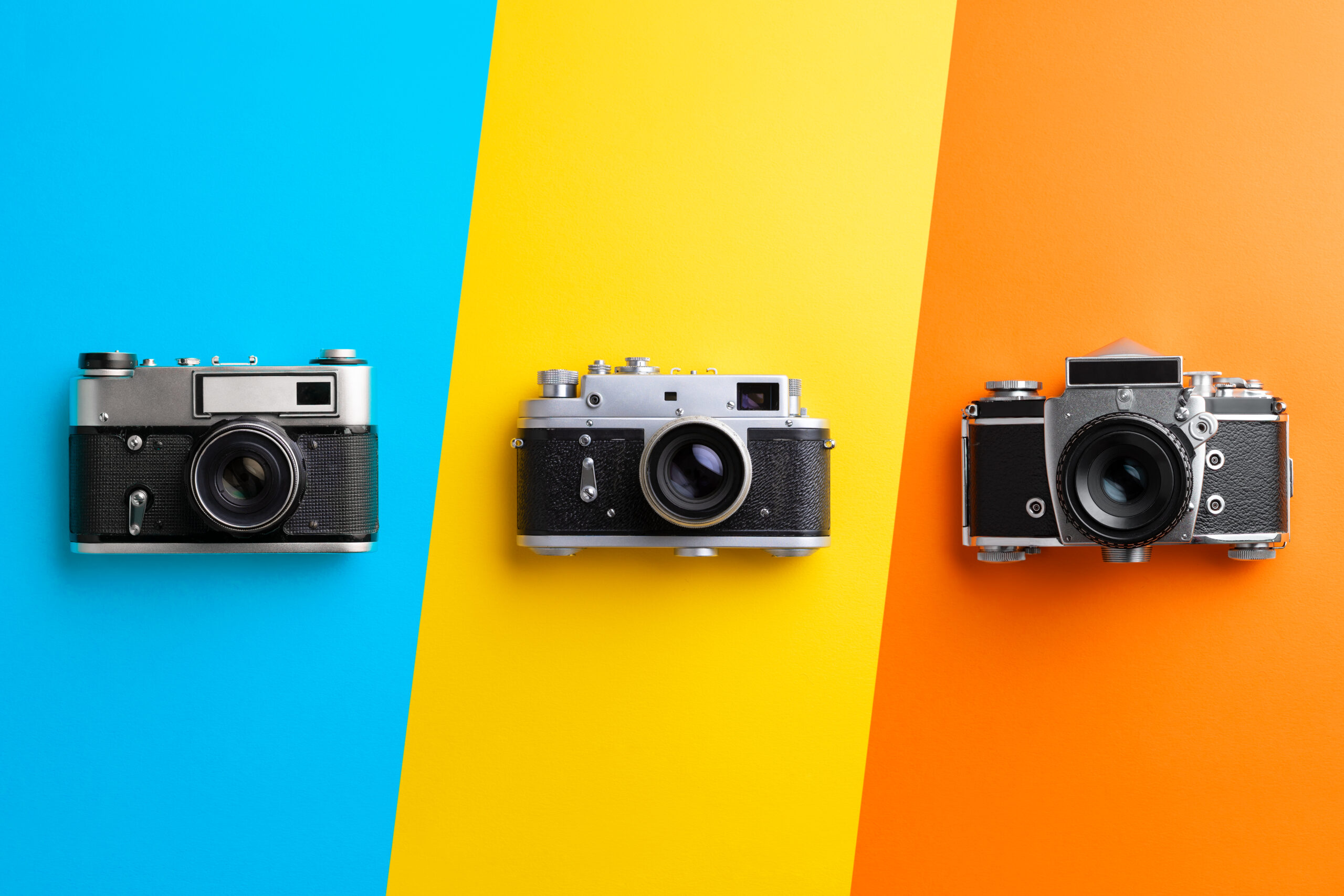 Multiple vintage cameras over colorful background